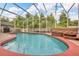 Relaxing screened-in pool with a hot tub, surrounded by a patio and lush greenery at 3196 Verbena Ct, Deltona, FL 32725