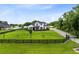 The aerial view showcases a home with expansive green lawn surrounded by a black fence and mature trees at 3201 Dallas Blvd, Orlando, FL 32833