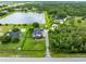 An aerial view of a property featuring a home, pool, pond, outbuilding, and mature trees creates a picturesque setting at 3201 Dallas Blvd, Orlando, FL 32833