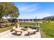 Fire pit with benches and picnic tables looking over the lake with lush landscaping at 3201 Dallas Blvd, Orlando, FL 32833