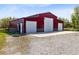 A spacious outbuilding with three garage doors sits on a gravel driveway at 3201 Dallas Blvd, Orlando, FL 32833