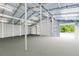 The outbuilding features bright interior lighting, a concrete floor, white metal walls, and access through garage doors at 3201 Dallas Blvd, Orlando, FL 32833