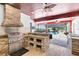 An outdoor kitchen with stainless steel grill, stone accents, and tiled flooring is open to a screened-in pool area at 3201 Dallas Blvd, Orlando, FL 32833
