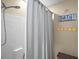 Bright bathroom features a tiled shower with a gray curtain and beach-themed decor at 3271 Settlers Trl, St Cloud, FL 34772