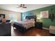 This bedroom features wood floors, a ceiling fan, and a dark green accent wall at 3271 Settlers Trl, St Cloud, FL 34772