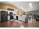 Sunlit kitchen with skylights, a breakfast bar, stainless steel appliances, and hardwood floors at 3271 Settlers Trl, St Cloud, FL 34772