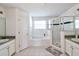 Bright bathroom with double sinks, tiled floors, a soaking tub, and a glass-enclosed shower at 331 Bridgewater Dr, Davenport, FL 33897