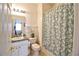 Cozy bathroom featuring a shower with decorative curtain, white fixtures, and tiled flooring at 331 Bridgewater Dr, Davenport, FL 33897