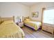 Bright bedroom featuring two twin beds with yellow patterned bedding, complemented by wood-look flooring at 331 Bridgewater Dr, Davenport, FL 33897