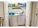Laundry room features a newer washer and dryer with overhead shelving unit for convenient storage at 331 Bridgewater Dr, Davenport, FL 33897