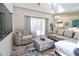 Comfortable living room with a plush sofa, accent chair and stylish floral ottoman at 331 Bridgewater Dr, Davenport, FL 33897