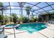 Beautiful screened-in pool and spa surrounded by lush landscaping and seating at 331 Bridgewater Dr, Davenport, FL 33897