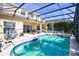 Beautiful screened-in pool and spa surrounded by comfortable seating and lush landscaping at 331 Bridgewater Dr, Davenport, FL 33897