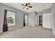 Spacious carpeted bedroom with ceiling fan, two windows, closet, and ensuite bathroom at 3757 Conroy Rd # 2525, Orlando, FL 32839