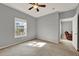 Bedroom with neutral walls, ceiling fan, window, and carpet flooring next to the living area at 3757 Conroy Rd # 2525, Orlando, FL 32839
