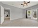 Large bedroom with neutral colored walls and carpeting, ceiling fan, with balcony entrance at 3757 Conroy Rd # 2525, Orlando, FL 32839