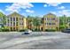 Three story tan condo building with black shutters, white columns, and landscaping in a parking lot at 3757 Conroy Rd # 2525, Orlando, FL 32839