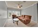 Living room showcasing a comfortable brown sofa, chair, table, ceiling fan, and bright natural light at 3757 Conroy Rd # 2525, Orlando, FL 32839