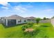 Spacious backyard with lush green grass, privacy fence, and tropical trees at 3817 Heartleaf Ln, Mount Dora, FL 32757