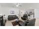 Cozy living room with tile floors, a ceiling fan, comfortable seating, and an adjacent kitchen area at 3817 Heartleaf Ln, Mount Dora, FL 32757