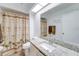 Bright bathroom featuring a granite countertop, skylight, and a palm tree shower curtain at 4438 Pinebark Ave # 4, Orlando, FL 32811