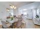 Bright dining area features a glass table, chandelier, and flows into a modern kitchen at 4438 Pinebark Ave # 4, Orlando, FL 32811