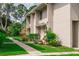 Townhome property featuring manicured landscaping, a pathway, and a clean, well-maintained exterior at 4438 Pinebark Ave # 4, Orlando, FL 32811