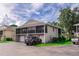 Exterior view of a well-kept townhome complex, featuring screened patios, attached garages, and tidy landscaping at 4438 Pinebark Ave # 4, Orlando, FL 32811