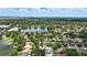 Expansive aerial view showcasing the homes in a lush, green neighborhood surrounding a tranquil lake with a city skyline in the distance at 4825 Waterwitch Point Dr, Orlando, FL 32806