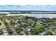 Picturesque aerial view of a residential neighborhood featuring tree-lined streets, well-maintained lawns, and a large lake in the background at 4825 Waterwitch Point Dr, Orlando, FL 32806
