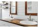 Bright bathroom featuring white vanity with double sinks, wood countertops, and modern hardware at 4825 Waterwitch Point Dr, Orlando, FL 32806
