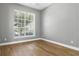 Neutral bedroom featuring natural light from large window, accentuated by hardwood flooring at 4825 Waterwitch Point Dr, Orlando, FL 32806