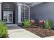 Close up of front door with architectural pillars and charming seating with landscaping at 4825 Waterwitch Point Dr, Orlando, FL 32806