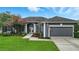 Charming gray home with a well-manicured lawn, beautiful landscaping, and an inviting entrance at 4825 Waterwitch Point Dr, Orlando, FL 32806