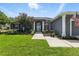 Beautiful gray home with lush green lawn and manicured landscaping at entrance and garage at 4825 Waterwitch Point Dr, Orlando, FL 32806