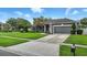 Well-maintained single-story home with manicured lawn, two-car garage, and charming landscaping at 4825 Waterwitch Point Dr, Orlando, FL 32806