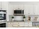 Close-up of kitchen featuring modern stainless steel appliances and white subway tile backsplash at 4825 Waterwitch Point Dr, Orlando, FL 32806