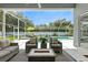Inviting screened patio featuring comfortable seating and a view of the sparkling pool and backyard at 4825 Waterwitch Point Dr, Orlando, FL 32806