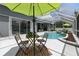 Charming outdoor dining area overlooking the sparkling pool and lush landscaping in screened-in lanai at 4825 Waterwitch Point Dr, Orlando, FL 32806