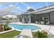 Relaxing in-ground pool with water feature, lush landscaping, and outdoor seating in screened-in lanai at 4825 Waterwitch Point Dr, Orlando, FL 32806