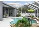 Relaxing in-ground pool with water feature, lush landscaping, and outdoor seating in screened-in lanai at 4825 Waterwitch Point Dr, Orlando, FL 32806