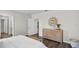 Bright bedroom with paneled accent wall, dresser with mirror, and a bench at the foot of the bed with wood laminate flooring at 5202 Orchard Oriole Loop, Bartow, FL 33830
