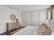 Bright bedroom with paneled accent wall, dresser with mirror, and a bench at the foot of the bed with wood laminate flooring at 5202 Orchard Oriole Loop, Bartow, FL 33830