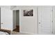 Bedroom view showing an open doorway, a sports photo on the wall, and a white door at 5202 Orchard Oriole Loop, Bartow, FL 33830