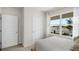 Bright bedroom view showcasing a bed, two doors, and a window with a view of new construction at 5202 Orchard Oriole Loop, Bartow, FL 33830