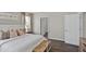 Bright bedroom featuring a large bed with decorative pillows, side tables, and access to a bathroom with wood laminate flooring at 5202 Orchard Oriole Loop, Bartow, FL 33830