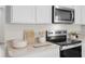 Close-up of modern stainless steel oven with white counters, wooden accents, and minimalist design at 5202 Orchard Oriole Loop, Bartow, FL 33830