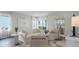 Bright living room with neutral decor, comfortable seating, and view into the kitchen and backyard at 5202 Orchard Oriole Loop, Bartow, FL 33830