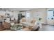 Bright living room featuring modern furniture, open floor plan, and a view of the kitchen with a stainless steel refrigerator at 5202 Orchard Oriole Loop, Bartow, FL 33830