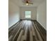 Bright bedroom with hardwood floors, ceiling fan, and large window overlooking the backyard at 534 S Adelle Ave, Deland, FL 32720